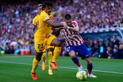 Jules Koundé disputa el balón ante Carrasco. 
