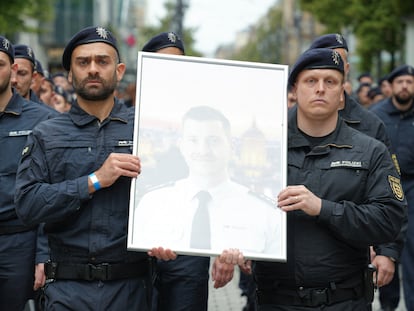 Agentes de policía muestran una foto de su compañero asesinado en Mannheim, Rouven Laur, durante un acto de conmemoración.