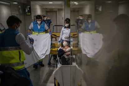 Los técnicos Héctor Martínez y Francisco Miguel Pérez se disponen a tapar a Mari Paz, para trasladarla al Hospital 12 de Octubre. Al fondo, la enfermera Marta de la Torre.