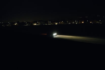 Un coche en una carretera visto desde el tren nocturno entre Viena y Milán.
