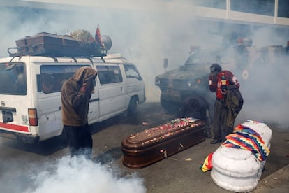 Los partidarios del expresidente boliviano Evo Morales se cubren de los gases lacrimógenos lanzados por las fuerzas de seguridad mientras transportan ataúdes de las personas asesinadas durante enfrentamientos recientes en Senkata (Bolivia), el 21 de noviembre.