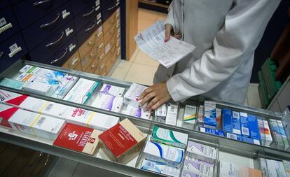 Una farmacéutica busca un medicamento en un establecimiento de Barcelona.