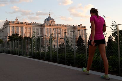 Una mujer camina, a última hora de la tarde del lunes, en los aledaños del Palacio Real de Madrid.