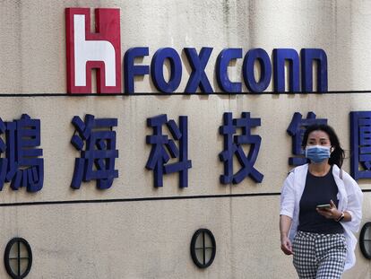 Una mujer pasa junto al logotipo de Foxconn en el exterior del edificio de la empresa en Taipei, Taiwán.
