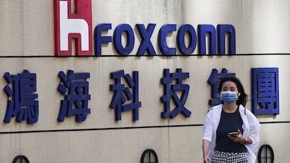 Una mujer pasa junto al logotipo de Foxconn en el exterior del edificio de la empresa en Taipei, Taiwán.