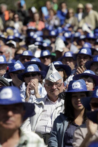 Un periódico también sirvió para protegerse del sol al público del mitin del PP. El mismo método para dos simpatizantes de diferente color político.