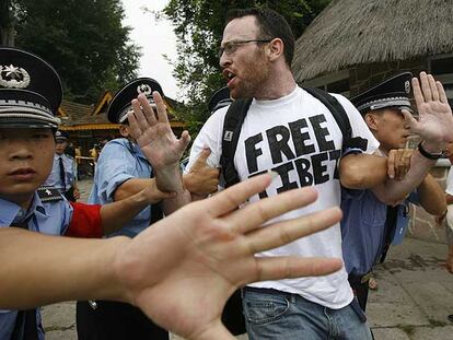 Policías chinos detienen a un activista que protesta por la situación en Tíbet.