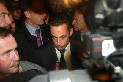 Nicolas Sarkozy, rodeado de guardespaldas durante un paseo ayer por los Campos Elíseos para observar la situación.