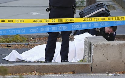 Un agente junto al cadáver de una persona tras ser atropellada en el carril bici en la ciudad de Nueva York.