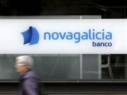 Una mujer pasa por delante de una oficina de Novagalicia Banco. EFE/Archivo