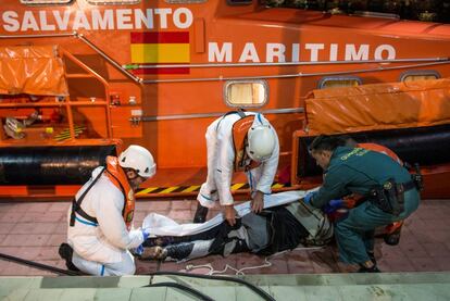 Los equipos de rescate cubren en el puerto de Melilla el cuerpo de uno de los cuatro migrantes muertos.