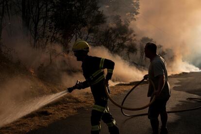 El intenso calor y el esfuerzo en la tarea por reducir las llamas han provocado que uno de los bomberos forestales de la brigada de Laza que lucha contra las llamas haya sido evacuado en ambulancia a un centro hospitalario. En la imagen, los bomberos realizan labores de extinción en el incendio forestal en Cualedro, en Ourense.