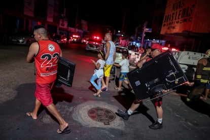 Os moradores tentam salvar suas posses do fogo.