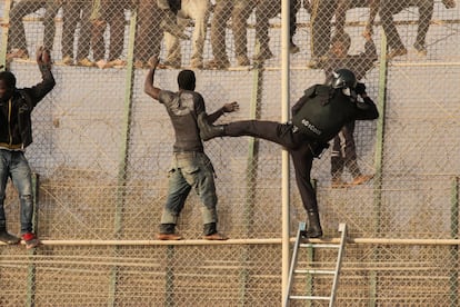 Inmigrantes subsaharianos se enfrentan a agentes de la guardia civil en la valla de Melilla en 2014