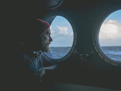 Un marinero observa el horizonte en la mar a través de un ojo de buey. GETTY