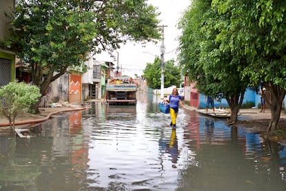 Maria das Graças de Andrade caminha pela rua Tite de Lemos, no Jardim Pantanal, nesta terça-feira. Via estava alagada desde domingo.