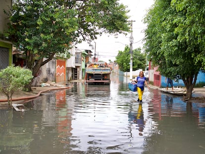 Maria das Graças de Andrade caminha pela rua Tite de Lemos, no Jardim Pantanal, nesta terça-feira. Via estava alagada desde domingo.