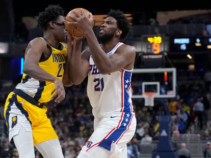 Philadelphia 76ers center Joel Embiid, right, moves against Indiana Pacers forward Serge Ibaka during the first half of an NBA basketball game in Indianapolis, Saturday, March 18, 2023.