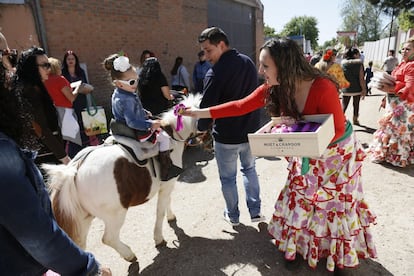 Una mujer ofrece adornos de la romería para los caballos.