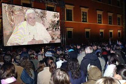 Ciudadanos de Varsovia ven en una pantalla gigante la entrevista al Papa.