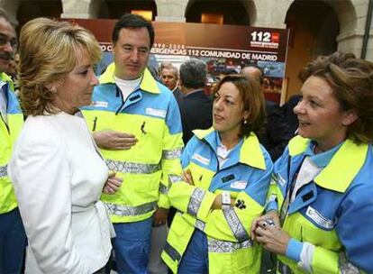 Esperanza Aguirre conversa con técnicos sanitarios durante el homenaje a los servicios de emergencia.