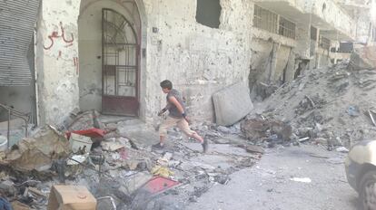 El 17 de mayo de 2014, un niño corre a través de una calle cubierta de escombros, entre edificios destruidos en la zona de la Ciudad Vieja de Homs. En aquel momento, los residentes desplazados regresaron para inspeccionar los daños de sus hogares y negocios, tras un acuerdo negociado entre los combatientes y el Gobierno.