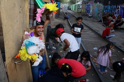 Migrantes varados en la Ciudad de Mxico rompen una pi?ata en un campamento irregular, este 24 de diciembre. 