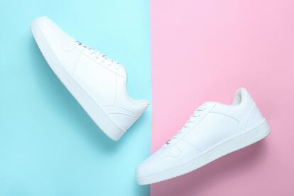 Fashionable white sneakers on a colored pastel background, minimalism, top view, creative layout, step