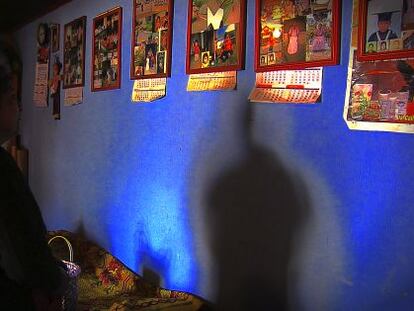 Lucia Santos Coyoi mira las fotos de su hijo colgadas en la pared de su casa.