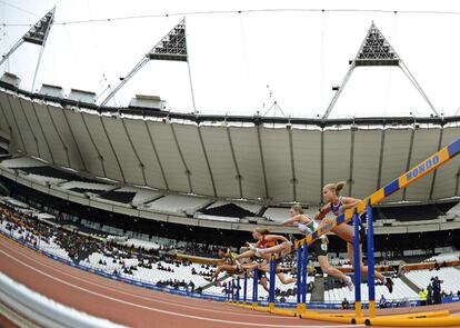 Las atletas compiten durante los 100m vallas femeninos.