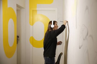 Una de las artistas trabajando en una pared del establecimiento.