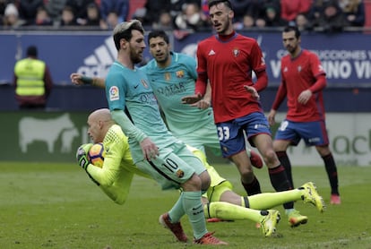 El portero del Osasuna Nauzet Pérez (i) atrapa un balón ante el delantero argentino del FC Barcelona, Messi.
