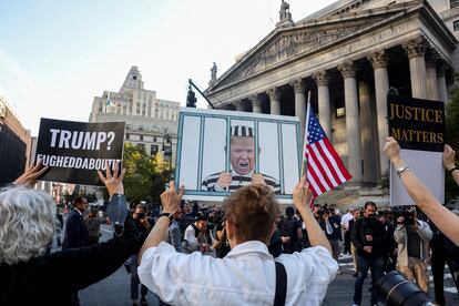 Anti-Trump demonstrators hold up signs on the day of the start of the trial at a Manhattan courthouse in New York City, on October 2, 2023.