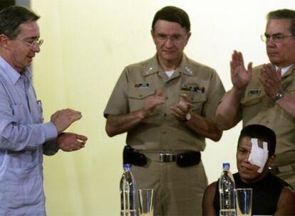 Álvaro Uribe (izquierda) y dos jefes militares aplauden a Isaza, el guerrillero que huyó con Lizcano.