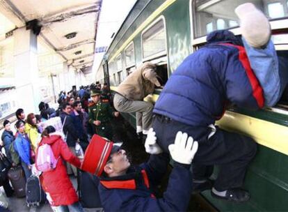 Varios pasajeros entran a un tren por la ventana en Wuxi, en la provincia de Jiangsu