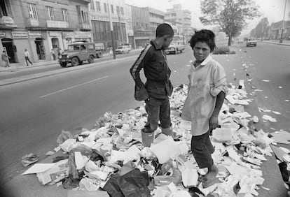 Tres niños buscan entre la basura en una calle de la capital colombiana, en enero de 1983.