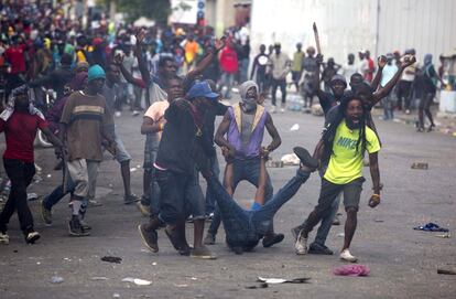 Los manifestantes arrastran el cuerpo de un compañero muerto hacia la policía, como forma de protesta después de que la policía disparase contra la multitud, durante una manifestación que exigía la renuncia del presidente haitiano, Jovenel Moise, cerca del palacio presidencial en Puerto Príncipe (Haití).