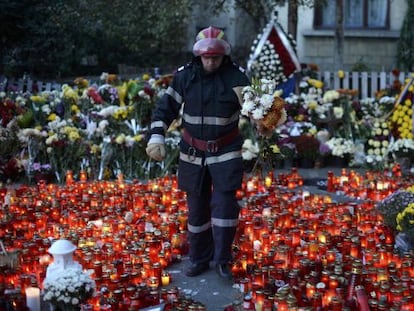 Un bombero deposita flores en la entrada del club incendiado en Bucarest, el domingo.