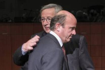 El presidente del Eurogrupo, Jean-Claude Juncker (detrás), y el ministro español de Economía y Competitividad, Luis de Guindos. EFE/Archivo