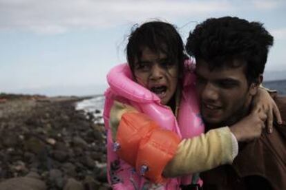 Un refugiado sirio sostiene a una niña a su llegada a la isla de Lesbos, Grecia./ © UNICEF