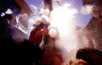 Los vecinos lanzan agua desde los balcones a los turistas ante el intenso calor en la Tomatina 2014.