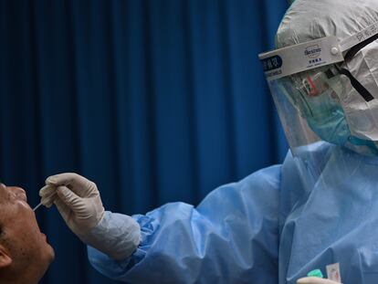 Un sanitario recoge una muestra de saliva para realizar el test del covid19