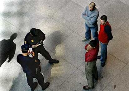 Unos policías comprueban, ayer, la documentación de unas personas en la estación de Atocha.