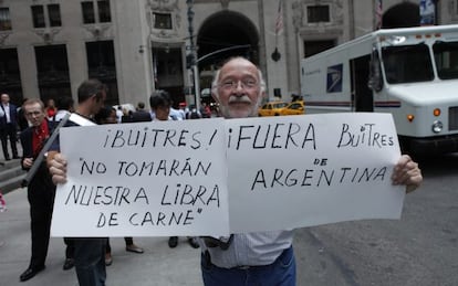Un argentino sostiene un cartel de denuncia a la salida del ministro de Econom&iacute;a argentino, Axel Kicillof, del consulado de Argentina en Nueva York.