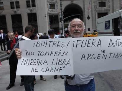 Un argentino sostiene un cartel de denuncia a la salida del ministro de Economía argentino, Axel Kicillof, del consulado de Argentina en Nueva York.