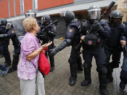 Un dona intenta dialogar amb antidisturbis a l&#039;escola Mediterr&agrave;nia de la Barceloneta.  