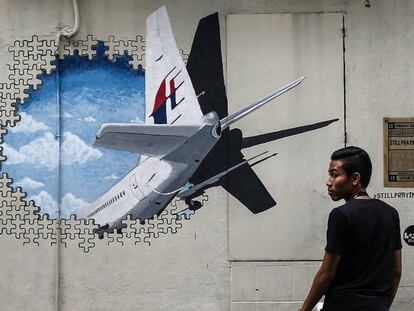 Un hombre que camina junto a un mural en recuerdo del vuelo MH370 en Shah Alam, a las afueras de Kuala Lumpur (Malasia), en marzo de 2015.