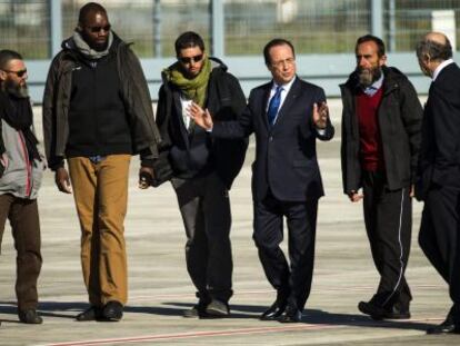 Los cuatros liberados, con Hollande y los ministros de Defenwsa y Exteriores.