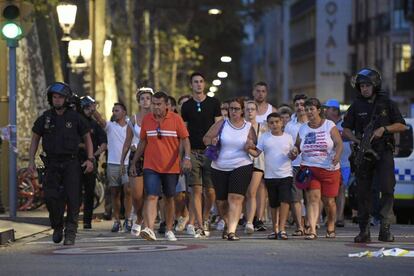 Policial acompanha clientes de uma loja nos arredores das Rambla após atentado