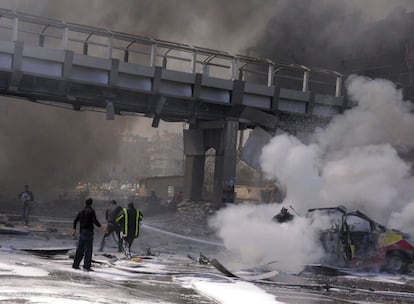 Bomberos tratan de extinguir las llamas que envuelven a los coches que resultaron alcanzados por la explosión de un coche bomba en el centro de Damasco, Siria.